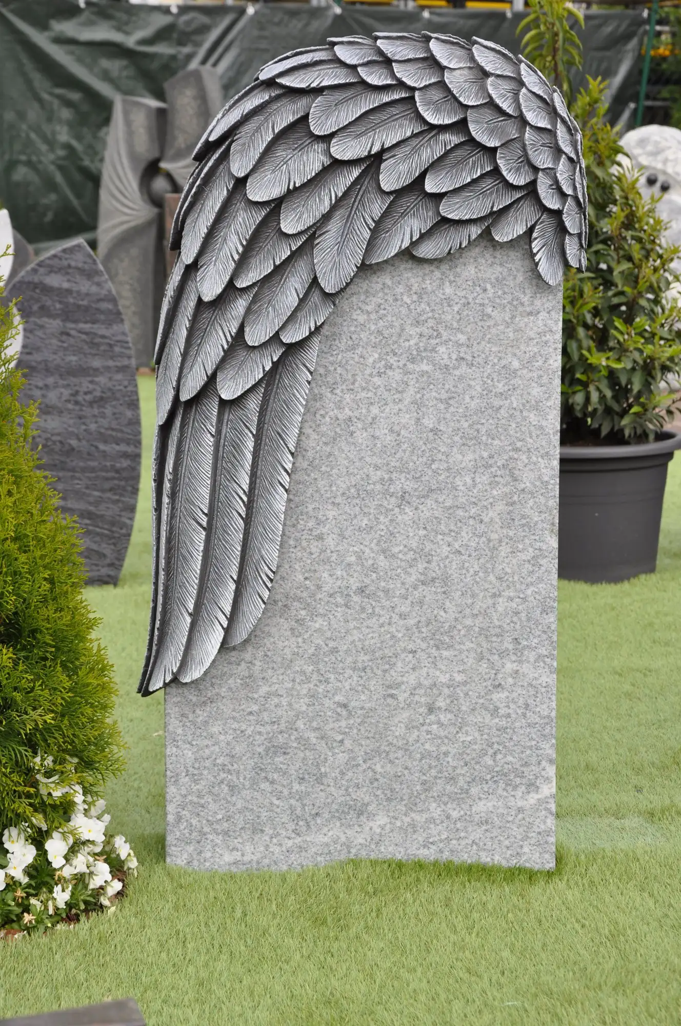 Heller Grabstein mit Flügel-Relief